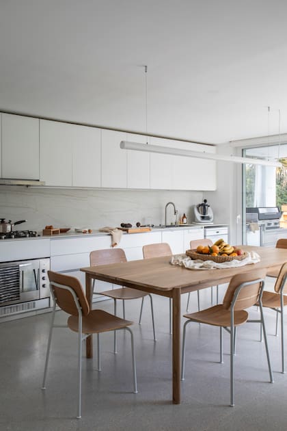 Mueble de cocina (Reno). Mesada y alzada de Dekton ‘Neural’ (Forte Dei Marmi para Canteras del Mundo). Tabla de madera con tope (Facundo Monge Muebles). Mesa y sillas (Estudio Te). Lámpara de techo (Imdi).