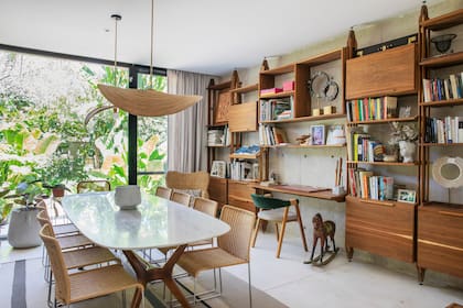 Mueble de incienso y roble, mesa con tapa de mármol, sillas apilables ‘Agnoli’ y luminarias colgantes tejidas (Estudio Bibiana Valeiras).
