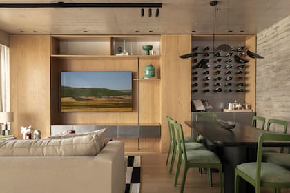 Mueble de TV con cava integrada, otro diseño del Estudio: la parte de madera fue ejecutada por Ral Design; la de acero inoxidable, por Hande Estudio. Objetos deco en verde (Sentido). Riel de iluminación orientable (Dimm).