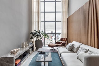 Mueble lineal bajo en piedra (Aline Roman Arquitetura) que integra la chimenea de etanol y los equipos de sonido. "Así conformamos un eje que organiza el espacio", explica la arquitecta.