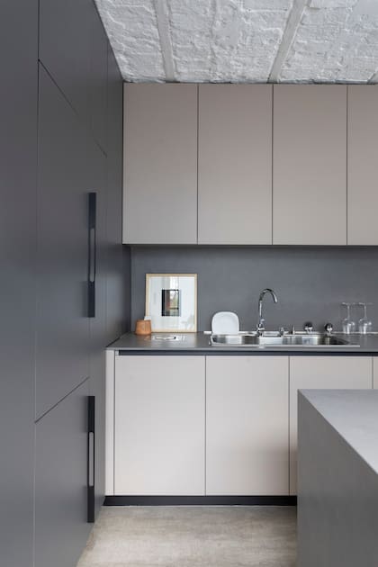 Muebles de cocina (Arq. Flor Fontana) con bajomesada y alacenas de melamina ‘Gris Arcilla’ (Egger). Mesada y alzada de Neolith ‘Pietra di Piombo’ (Marmolería Gaona).