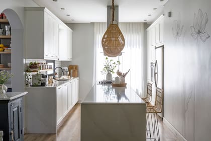 Muebles de cocina ‘Celebración’ blanco mate (De Otro Tiempo). Mesadas de Silestone ‘Calacatta’ (Ragolia). Banquetas (Basket Shop). Lámparas de techo (Compañía Nativa).