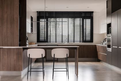 Muebles de cocina (Johnson). Banquetas (Malé) a medida de la barra. Lámpara colgante (Díaz Iluminación). Cortinas 'Wood Plus' (Riel Americano).