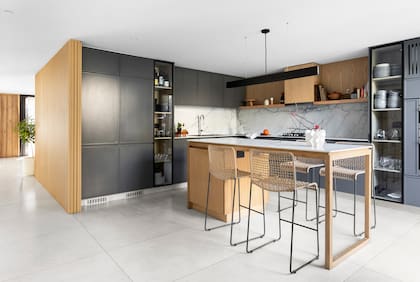 Muebles de cocina laqueados (Rafael Delgado Amoblamientos), vajilla y cristalería (Le Toton Casa), lámpara sobre la isla (San Isidro Luz), banquetas (Mausy Design), pie de torta y florero de cerámica (Philippa Deco).