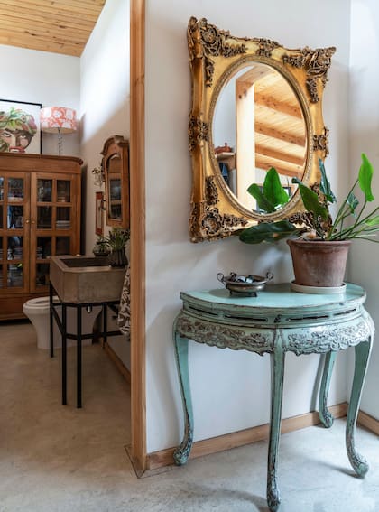 Muebles de estilo francés patinados o dorados a la hoja en el hall de entrada junto el acceso al toilette.