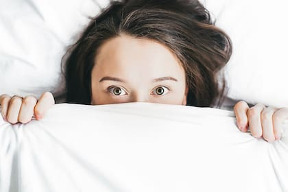 Mujer bajo una frazada pesada, ¿ayuda a dormir mejor?