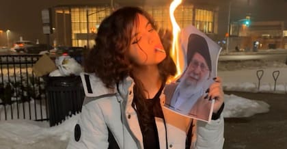 Mujer iraní enciende un cigarrillo con una foto en llamas del líder supremo Ali Khamenei (Publicado en X)