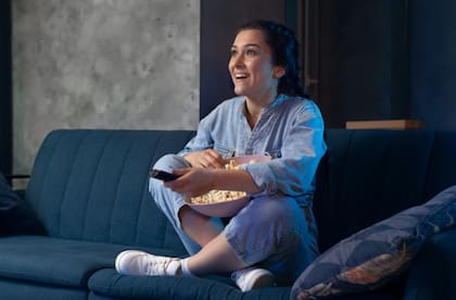 Mujer sorprendida mira una película en la televisión.
