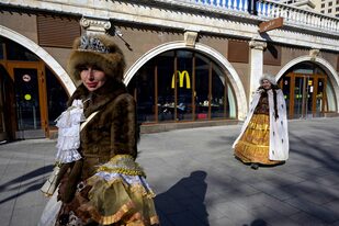 Mujeres caminan frente a un restaurante McDonald's en el centro de Moscú el 9 de marzo de 2022