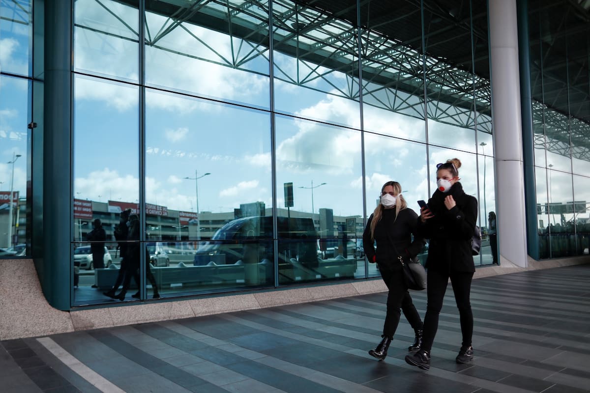 Mujeres con barbijos caminan fuera del aeropuerto Fiumicino de Roma, en el tercer día de un bloqueo sin precedentes en toda Italia impuesto para frenar el brote de coronavirus, en Roma, Italia, 12 de marzo de 2020