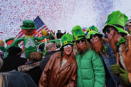 Mujeres con sombreros de duende y barbas falsas sonríen durante el desfile anual del Día de San Patricio en Boston. (AP Foto/Charles Krupa)