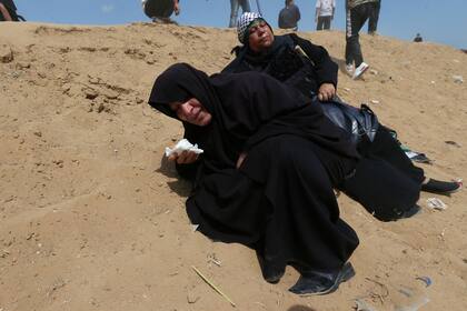 Mujeres palestinas reaccionan al gas lacrimógeno disparado por las tropas israelíes durante la protesta