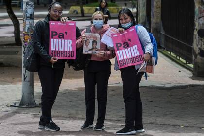 Mujeres posan con carteles de Gustavo Petro y Francia Marquez, en Bogotá. (Photo by Juan BARRETO / AFP)
