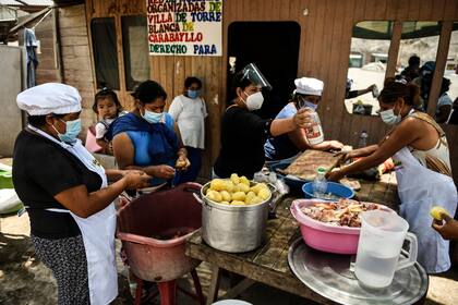 Mujeres voluntarias preparan la comida en un comedor en las afueras de Lima. La economía se deterioró fuertemente durante la pandemia, que ahora está en niveles récord