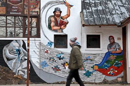 Mural en una pared de El Bolsón, con las figuras de Maldonado y Rafael Nahuel. Alguien pintó una esvástica