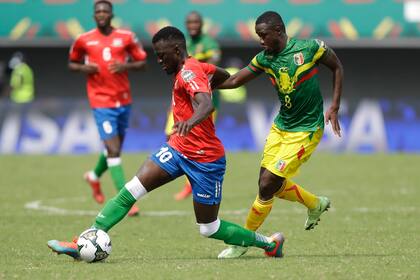 Musa Barrow de Gambia controla el balón lejos de Diadie Samassekou de Mali en el encuentro del grupo F de la Copa Africana de Naciones el domingo 16 de enero del 2022. (AP Foto/Sunday Alamba)