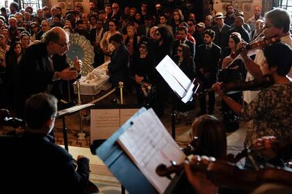Musicians perform during the wake for Brazilian cultural icon Joao Gilberto, where his widow Maria do Ceu Harris stands by his open coffin, behind center, during his wake at the Municipal Theater in Rio de Janeiro, Brazil, Monday, July 8, 2019. Joao Gilberto, one of the fathers of bossa nova music w