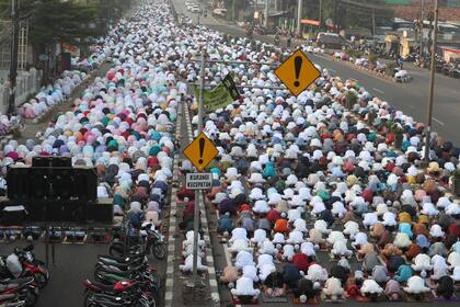 Musulmanes realizan la oración del Eid al-Fitr, que marca el final del mes sagrado del islam, el Ramadán, en una calle en Bekasi, en Java Occidental, Indonesia, el 13 de mayo de 2021. (AP Foto/Achmad Ibrahim)