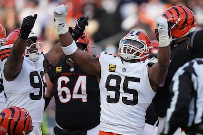 Myles Garrett (95), ala defensiva de los Browns de Cleveland, celebra con el ala defensiva Adin Hunt