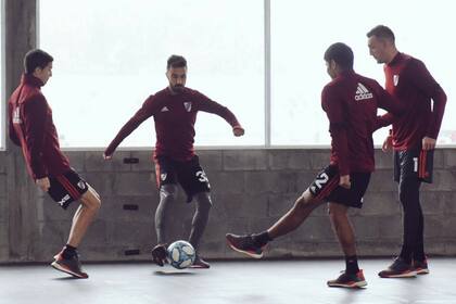 Nacho Fernández, Scocco, Robert Rojas y Armani, en el entrenamiento de este viernes, bajo techo: la lluvia pudo más en Ezeiza.
