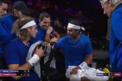 Nadal le explica a Tsitsitpas; detrás, Federer no puede contener la risa y los mira Björn Borg