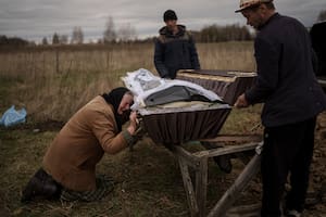 Nadiya Trubchaninova, de 70 años, llora junto al lado del féretro con los restos de su hijo, durante el funeral en el cementerio de Mykulychi, en las afueras de Kiev, Ucrania, el 16 de abril de 2022.