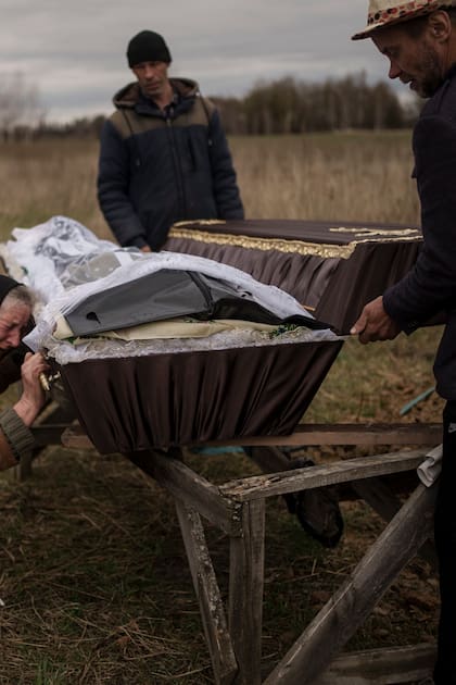 Nadiya Trubchaninova, de 70 años, llora junto al lado del féretro con los restos de su hijo, durante el funeral en el cementerio de Mykulychi, en las afueras de Kiev, Ucrania, el 16 de abril de 2022.