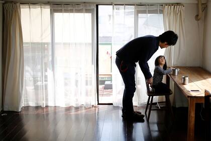 Naoki Numahata conversa con su hija en living de su departamento en Tokyo,