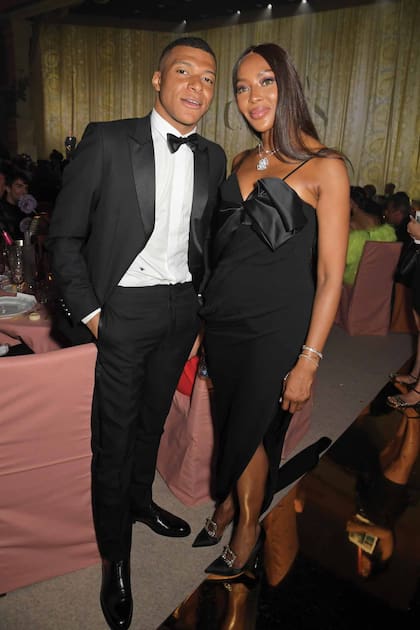 Naomi Campbell y el delantero del Paris Saint-Germain, Kylian Mbappé. La top optó por un total look negro de Schiaparelli protagonizado por un entallado vestido con cola y un moño XXL en el escote.