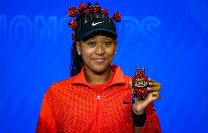 Naomi Osaka, con las rosas en el cabello, muestra su muñeco Labubu, al que llamó "Billie Jean Bling"
