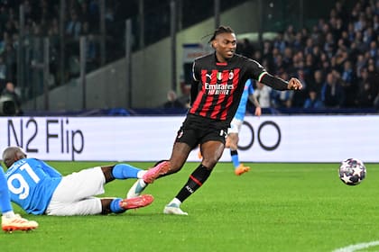 Napoli's French midfielder Tanguy Ndombele (L) attempts to tackle AC Milan's Portuguese forward Rafael Leao during the UEFA Champions League quarter-finals second leg football match between SSC Napoli and AC Milan on April 18, 2023 at the Diego-Maradona stadium in Naples. (Photo by Alberto PIZZOLI / AFP)