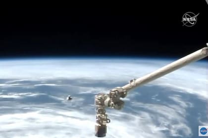 Esta captura de video de la NASA TV muestra la misión SpaceX Crew-1 a bordo del SpaceX Crew Dragon mientras se acerca a la Estación Espacial Internacional con la Tierra visible en la distancia