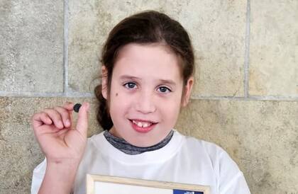 Nati Toyikar con la moneda que desenterró