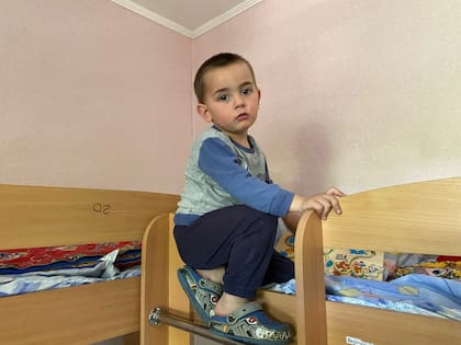 Nazar juega con su moto de plástico mientras su madre relata la destrucción en su ciudad