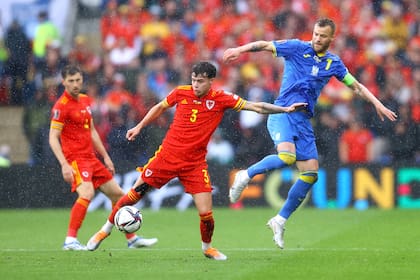 Neco Williams, de Gales, batalla contra Andriy Yarmolenko, el ucraniano autor del gol en contra, de cabeza