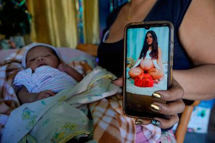 Neriuska muestra en su celular una foto de su sobrina Briggite Pérez, quien permanece hospitalizada, mientras cuida al bebé en su casa del barrio Blandín, el 5 de enero de 2021.