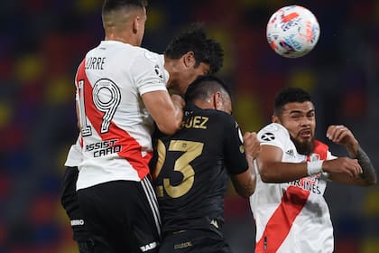 Nery Domínguez, de Racing, intenta cabecear entre varios jugadores de River.