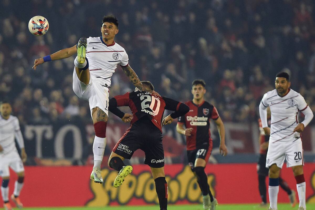 Néstor Ortigoza mira la acción entre Adam Bareiro y Julián Fernández, volante de Newell's; el Ciclón volvió a empatar