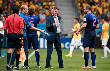 Netherlands' coach Louis van Gaal (C) speaks to Netherlands' defender Ron Vlaar (R) during the third place play-off football match between Brazil and Netherlands during the 2014 FIFA World Cup at the National Stadium in Brasilia on July 12, 2014.