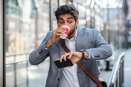 Never don't be late on business meeting. Worried businessman looking at his watch on the way to office. Business, lifestyle concept