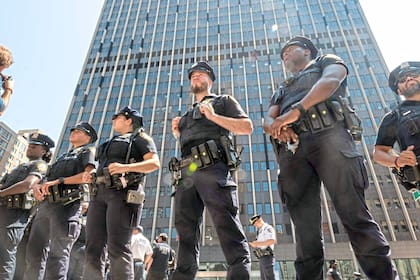 NEW YORK, NEW YORK - AUGUST 11: Police keep watch as protesters with the group Extinction Rebellion hold a rally and march outside the immigration court at the Jacob K. Javits Federal Building on August 11, 2025, in New York City. Numerous protesters were arrested after they stopped traffic outside the building, where federal agents, including members of ICE, have been arresting dozens of people daily as they arrive for their immigration hearings. Spencer Platt/Getty Images/AFP (Photo by SPENCER PLATT / GETTY IMAGES NORTH AMERICA / Getty Images via AFP)