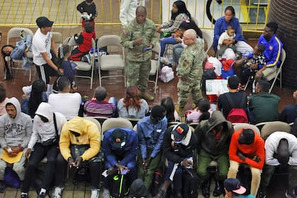 En la imagen, solicitantes de asilo recién llegados esperan en una zona de espera de la terminal de autobuses de la Autoridad Portuaria en Nueva York