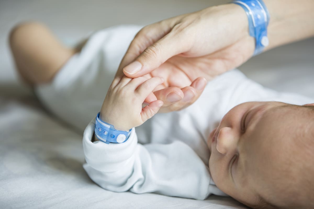 Newborn and his mom with name tag bracelets, first days of lif