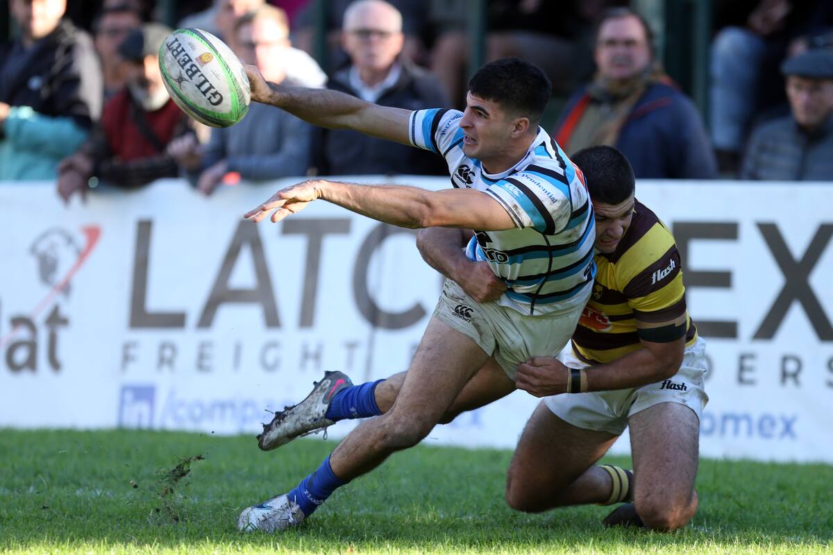 Nicanor Acosta suelta la pelota en medio del tackle de Tobías Bernabé en el preludio del segundo try de Jacinto Campbell; SIC se impuso con suficiencia a Belgrano y continúa arriba en el Top 12 de URBA.