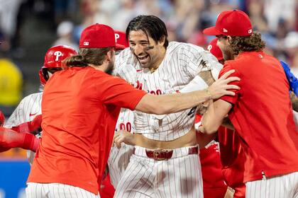 Nick Castellanos, de los Filis de Filadelfia, es felicitado después de que conectó un doble en la carrera de la victoria durante la décima entrada del juego de béisbol del equipo contra los Cerveceros de Milwaukee, el martes 4 de junio de 2024, en Filadelfia. (AP Foto/Laurence Kesterson)