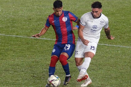 Nicolás Fernández, de San Lorenzo, intenta maniobrar ante la marca de Enzo Díaz; marcó el gol del partido