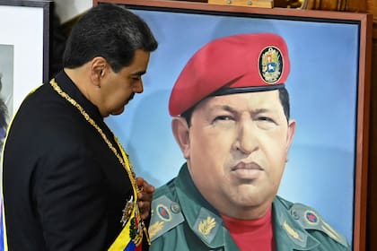 Nicolás Maduro junto al retrato de Hugo Chávez