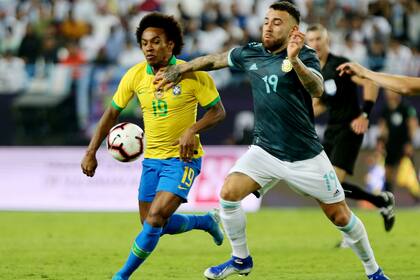 Nicolás Otamendi pelea por la pelota con el brasileño Willian durante el amistoso disputado en Arabia Saudita.
