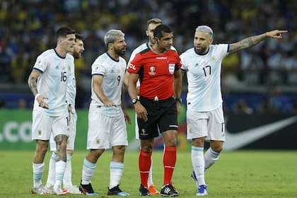 Nicolas Otamendi y Sergio Agüero le reclaman al árbitro Roddy Zambrano, de discreto desempeño en la semifinal contra Brasil
