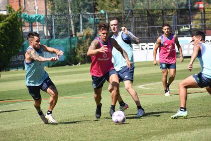 Nicolás Reniero domina la pelota en una práctica de Racing; lo rodean Jonathan Gómez, Aníbal Moreno y Matías Rojas